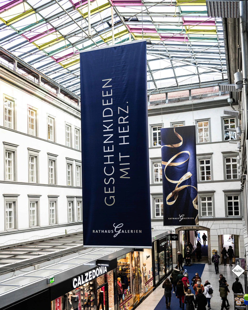 rathausgalerien innsbruck weihnachtskampagne pos große fahnen in der einkaufsmall mit herz