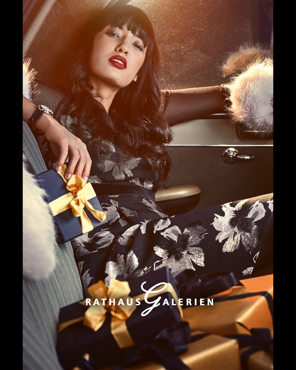 rathausgalerien innsbruck winterkampagne citylights frau in weihnachtlichem kleid in retro auto mit ganz vielen geschenken