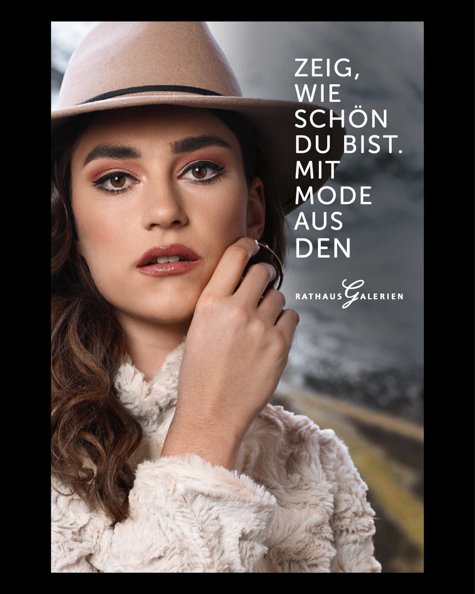 rathausgalerien innsbruck winterkampagne citylights frau mit hut in den Bergen
